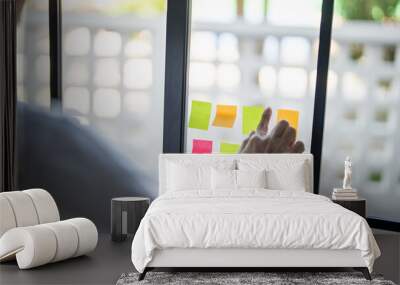 Man organizing project tasks Colorful sticky notes on glass of meeting room Wall mural